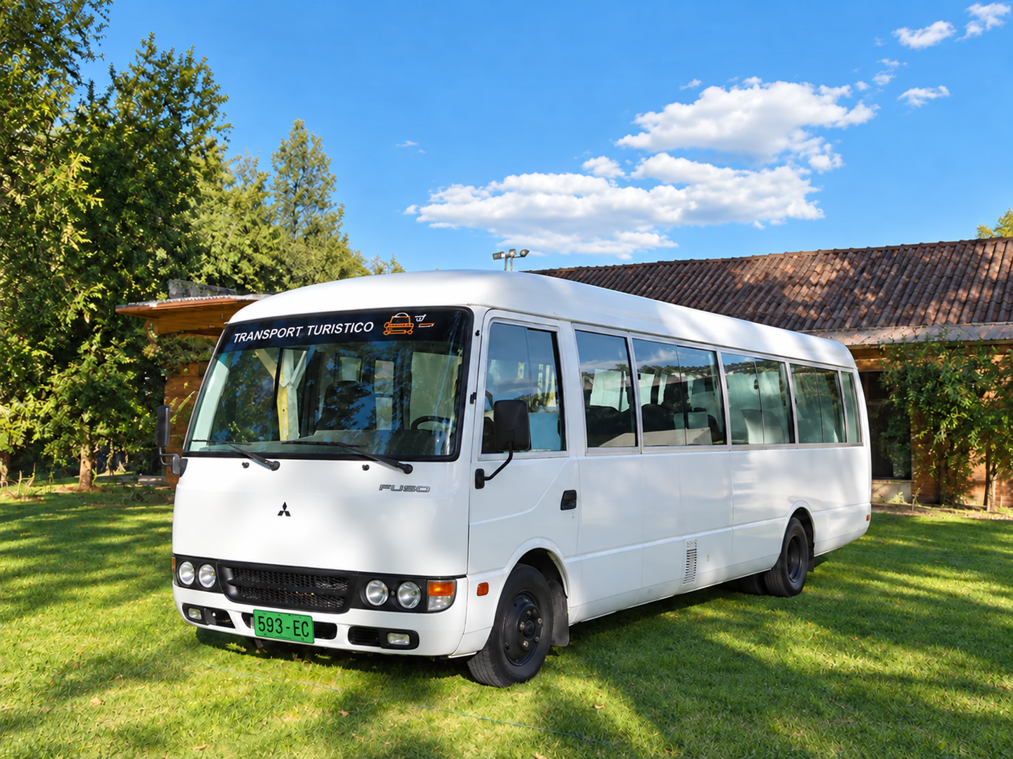 Buseta blanca de transporte turístico de Quinde Adventure en un jardín